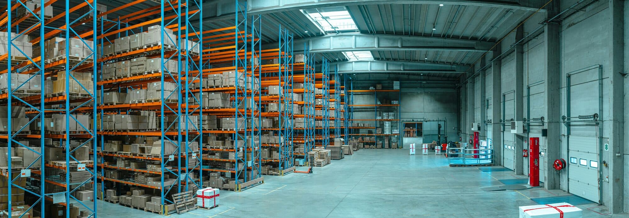 Warehouse aisles of stocked shelving, representing a logistics and fleet system